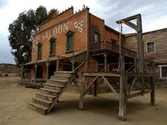 an old wooden building with stairs leading up to the upper level and second story area