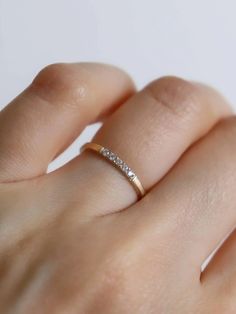 a woman's hand with a diamond ring on top of her finger and the other hand holding it