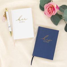 a notebook and pen sitting on top of a bed next to a rose flower with the word yes vows written in gold