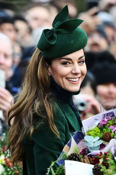 the woman is smiling while holding flowers