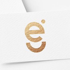 the letter e is made out of gold foil and has a circular shape on it