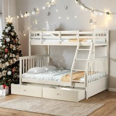 a white bunk bed sitting next to a christmas tree