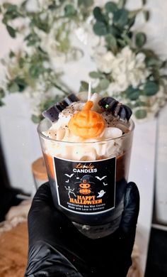 a hand holding up a cup filled with halloween treats