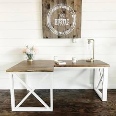 a white desk with a wooden sign above it and flowers on the table next to it