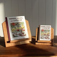 two wooden books are sitting on a table next to each other, one is open and the other is closed