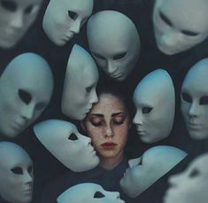 a woman surrounded by many white mannequins with her face in the center