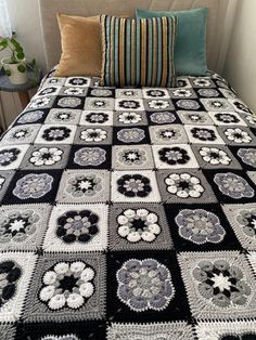 a black and white crocheted bedspread on a bed with two pillows