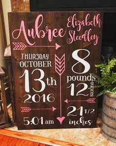 a wooden sign that has been decorated with baby's names and date on it