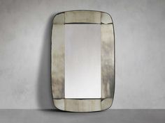 a mirror that is sitting on top of a table in front of a gray wall