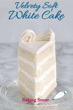 a slice of white cake sitting on top of a glass plate with the words velvety soft white cake