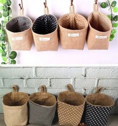 four baskets are hanging on the wall and one is filled with polka dot fabric bags