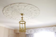 a chandelier hanging from the ceiling in a room with white walls and curtains