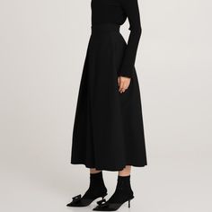 The black ankle-length Messina wool skirt is an elegant and classic piece of clothing. It is crafted from high-quality wool on a viscose lining. There are pleats at the front and back, which add volume and elegant shape to the skirt. Pockets in the side seams are a practical but discreet addition. Such a model combines classics with comfort and attention to detail, perfectly matching formal and casual styling. Main fabric: Wool 98%, Elastane 2% Lining: Viscose 100%    Dry cleaning only Formal Black Wool Skirt, Wool A-line Skirt For Work, Chic A-line Wool Skirt, Classic Wool A-line Skirt, Black Wool Skirt, Polish Clothing, Skirt Pockets, Animal Print Party, Knit Loungewear