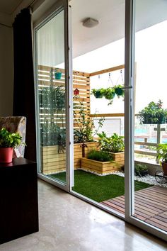 an open patio with potted plants on the side and sliding glass doors leading outside