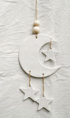 an ornament hanging from a string with stars and moon on the side,