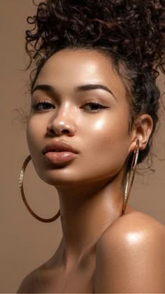 a woman with large hoop earrings on her head and an afro hairstyle is looking at the camera