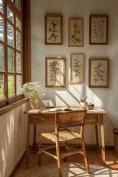 a wooden desk sitting in front of a window next to a wall with pictures on it