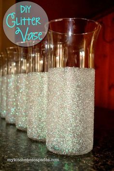 there are many wine glasses lined up on the table with glitter in them and one is empty