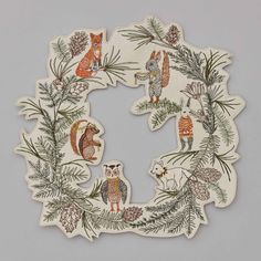 an image of a wreath with animals and pine branches on it's sides, in the shape of a circle