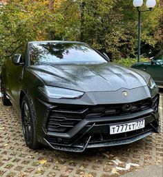 a black sports car parked in front of some trees