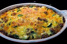 a casserole dish with meat and vegetables in it sitting on a stove top