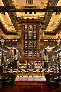 the interior of a restaurant with many tables and chairs, along with lots of bookshelves