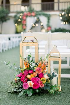 an arrangement of flowers and lanterns on the ground