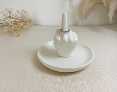 a small white object with a finger on it's end sitting on a plate