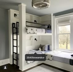 a bedroom with bunk beds and ladders next to a window in front of it