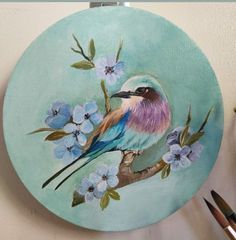 a painting of a bird sitting on a branch with blue flowers