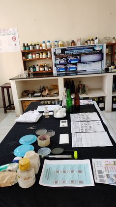 the table is covered with papers and bottles