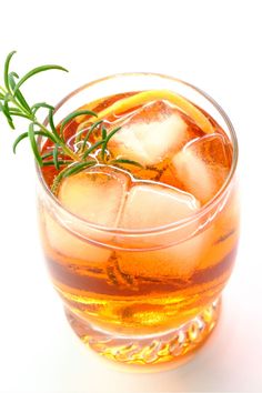 a glass filled with ice and garnished with rosemary