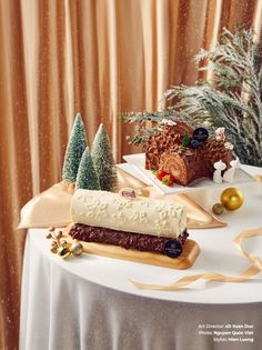 two desserts sitting on top of a table next to christmas trees and other decorations