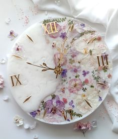 a white plate topped with flowers and roman numerals