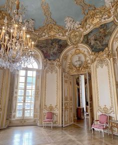 an ornate room with chandeliers and paintings on the walls