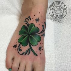 a foot with a shamrock tattoo on it