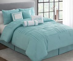 a bed with blue comforters and white pillows