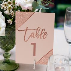 the table numbers are pink and have gold foil on them, along with white flowers