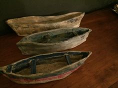 three wooden boats sitting on top of a wooden table