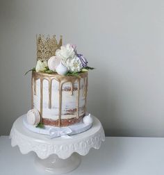 the cake is decorated with gold and white icing on it's tiers