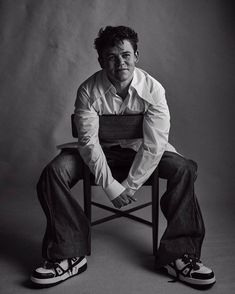 a black and white photo of a man sitting on a chair