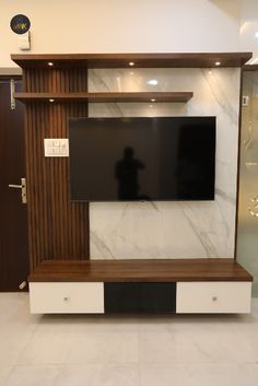 a flat screen tv sitting on top of a wooden entertainment center in a living room