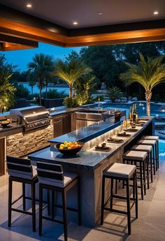 a large outdoor kitchen with an island and bar seating for six people at the end