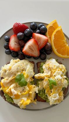 an open face sandwich with eggs, fruit and yogurt sits on a plate