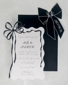 a black and white wedding card with a bow