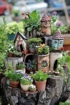 a tree stump filled with potted plants and miniature houses