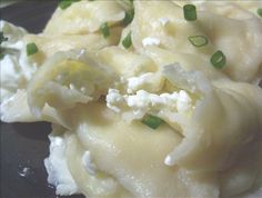 some food is sitting on a black plate and has green onions around the top portion