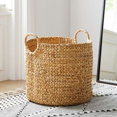 a basket sitting on top of a rug next to a mirror