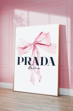 a pink poster with the word prada next to it in front of a pink wall