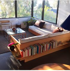 a living room filled with furniture and lots of books on top of it's shelves